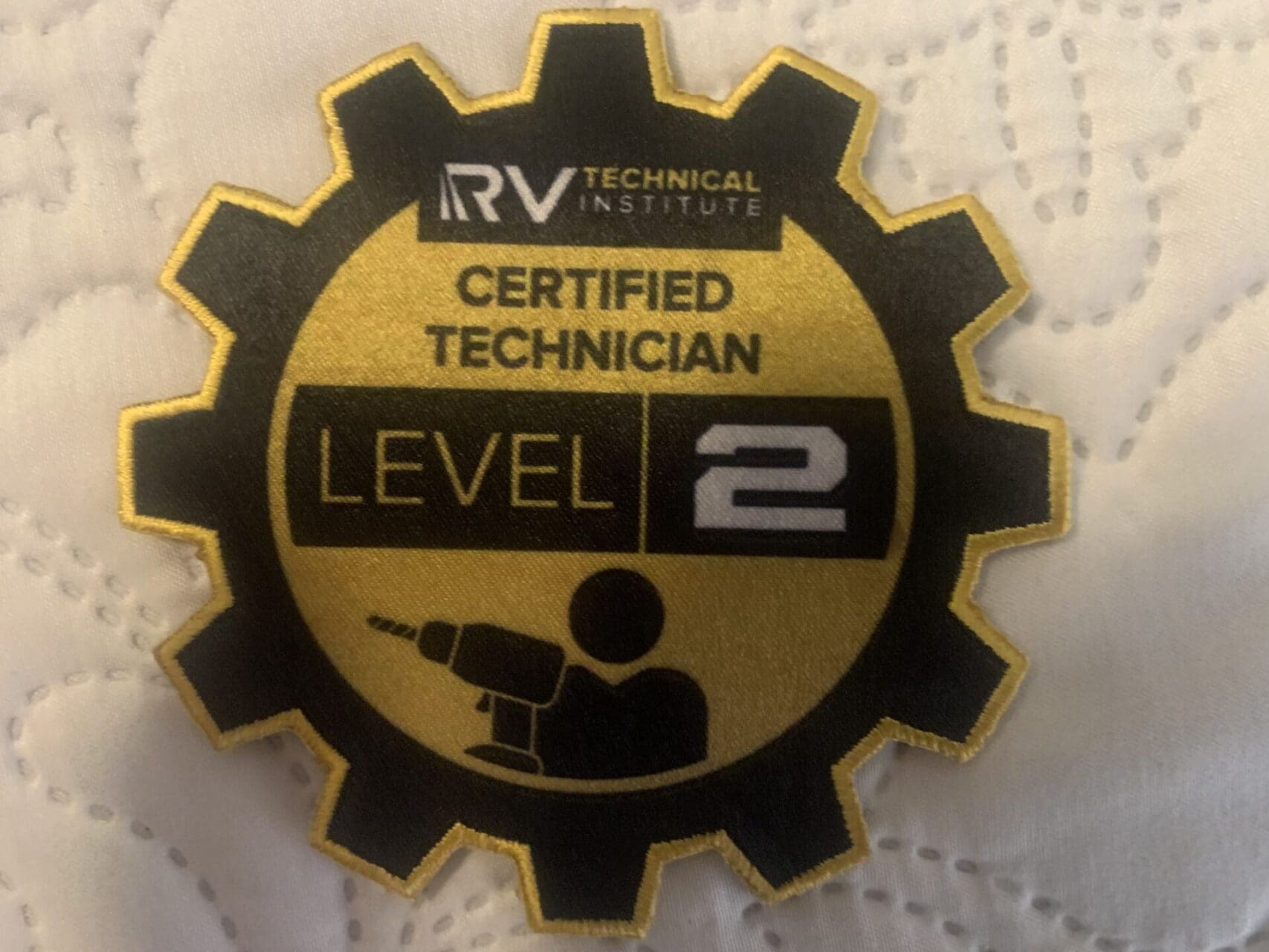 A pin that says certified technician level 2