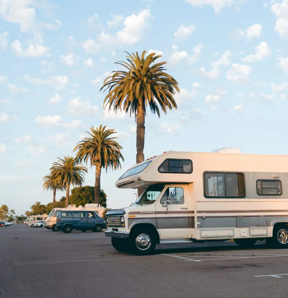 A white rv is parked in the middle of a street.